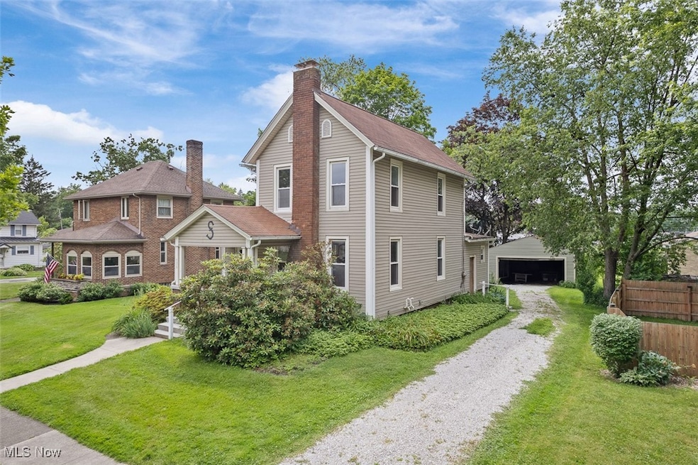 View of front of home featuring a detached garage and a chimney