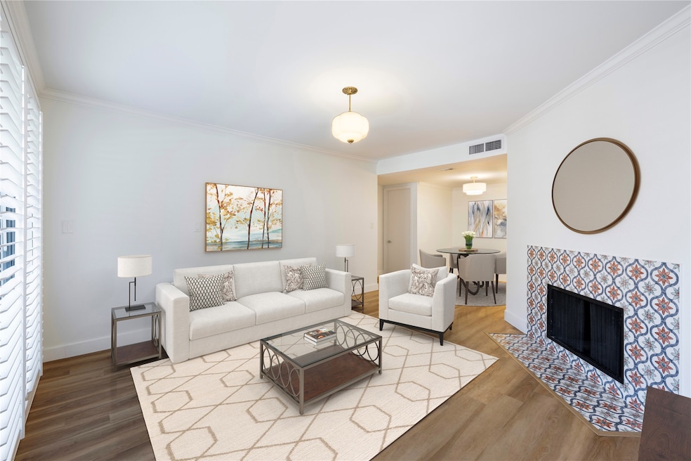 Inviting living room with a fireplace accented by Spanish Merola tile is open to the dining area for easy entertaining. Virtually staged.