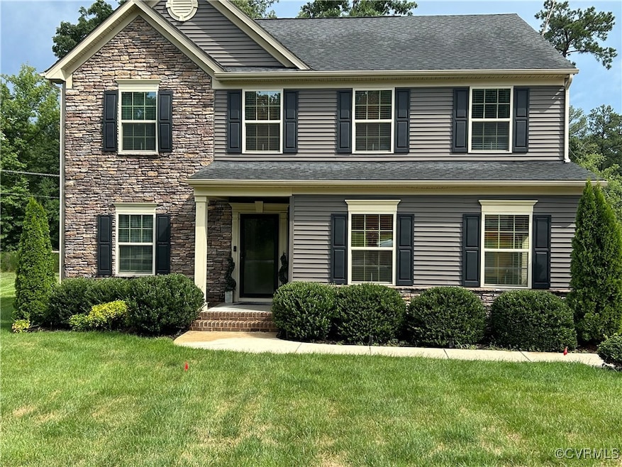 Traditional home featuring stone siding, a front l