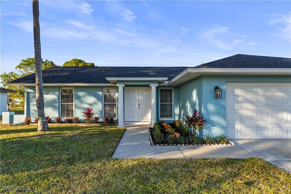 Single story home with a garage and a front yard