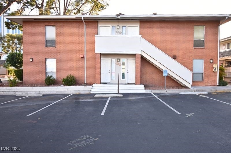View of property featuring uncovered parking and s
