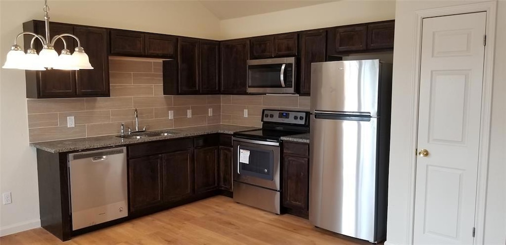 Kitchen with decorative backsplash, appliances wi