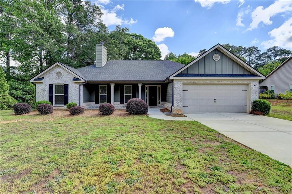 Ranch-style home with a front yard, driveway, an a