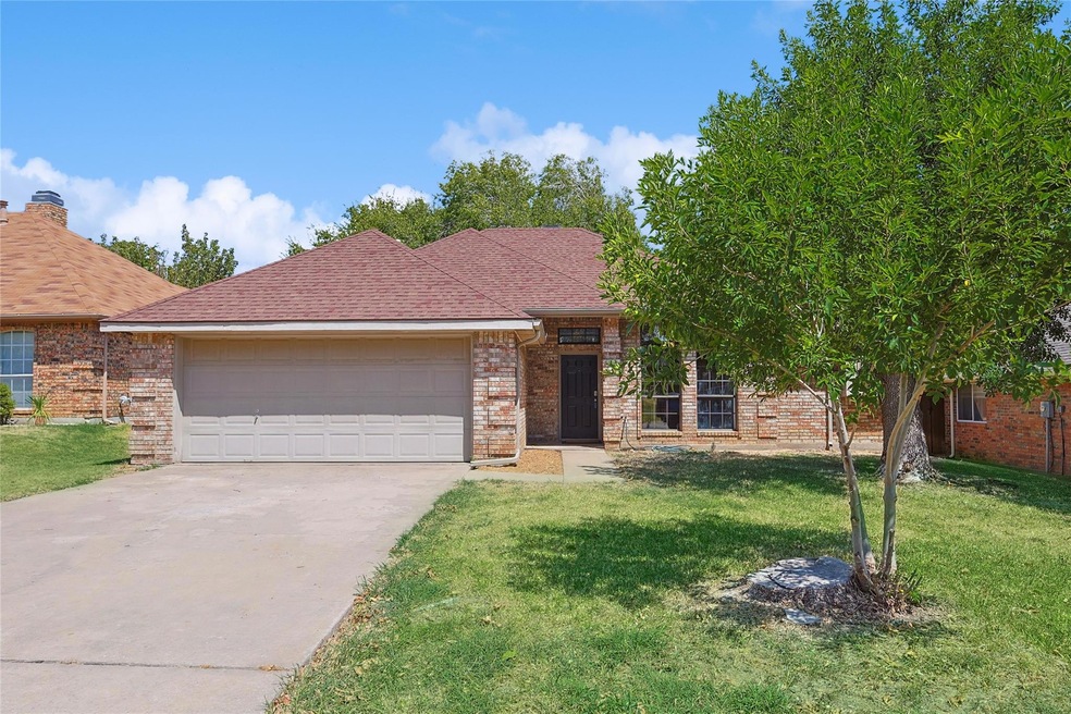 View of front of home with a front yard and a garage