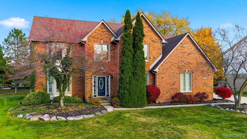 View of front of home featuring a front lawn, brick siding, and a shingled roof