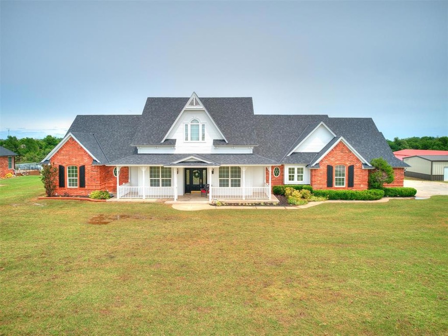 View of front facade featuring covered porch, a ga