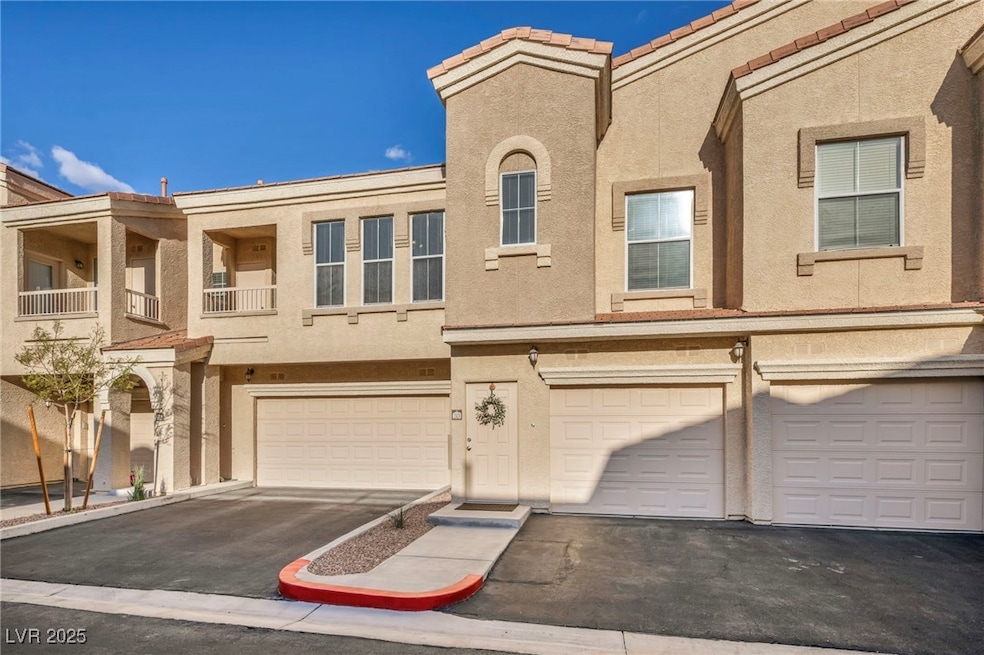 View of property featuring a tiled roof, a garage,