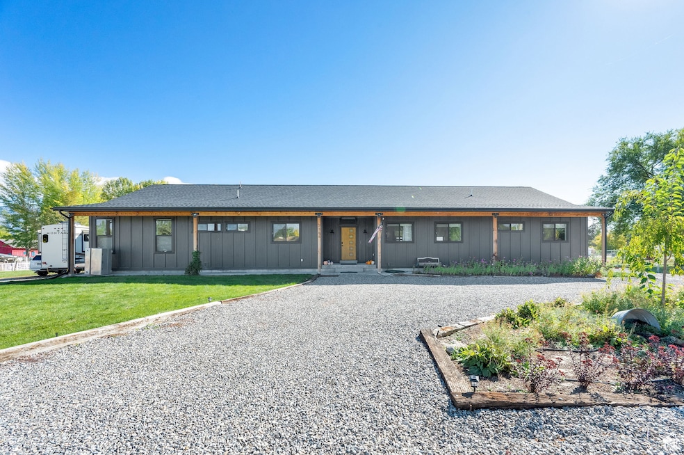 View of front of property featuring board and batten siding, a front yard, and a shingled roof