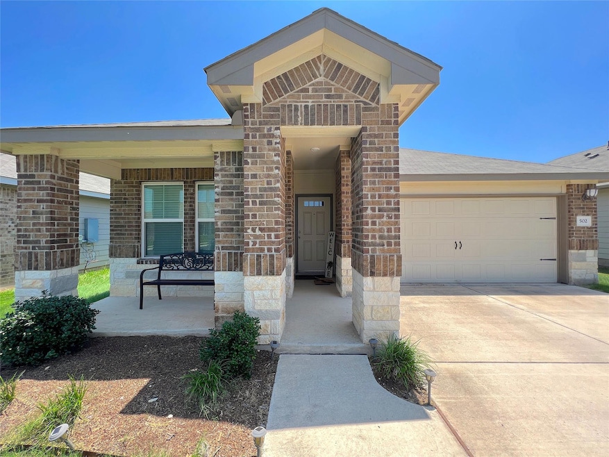 Doorway to property with brick siding, a garage, 