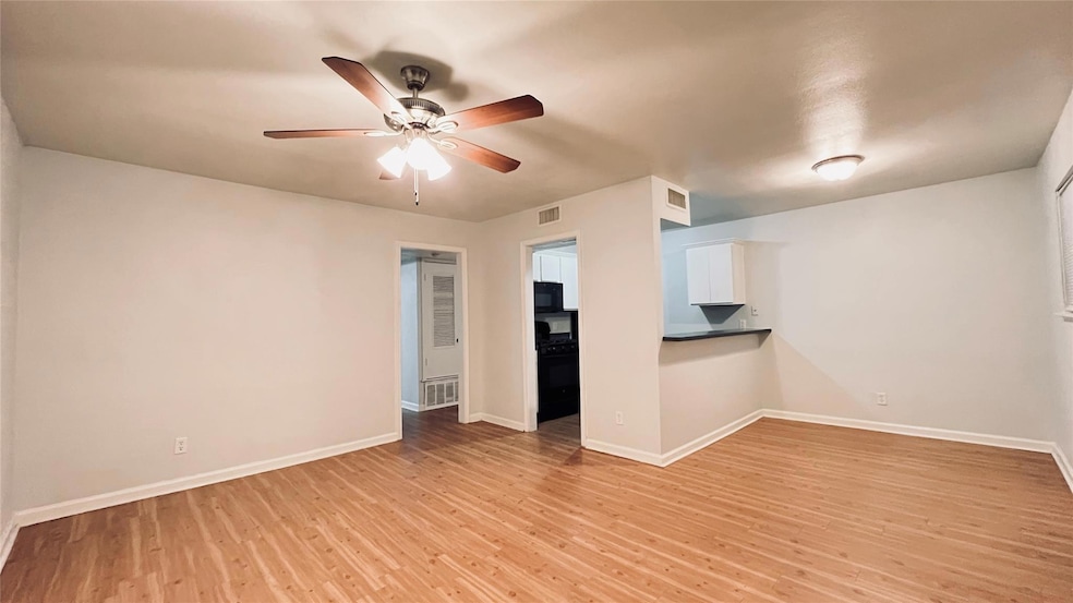 Empty room featuring a ceiling fan and light wood