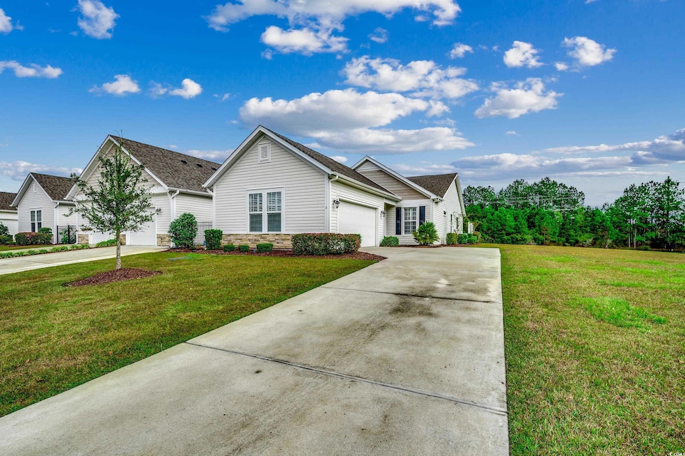 View of front of condo with a front yard and a gar