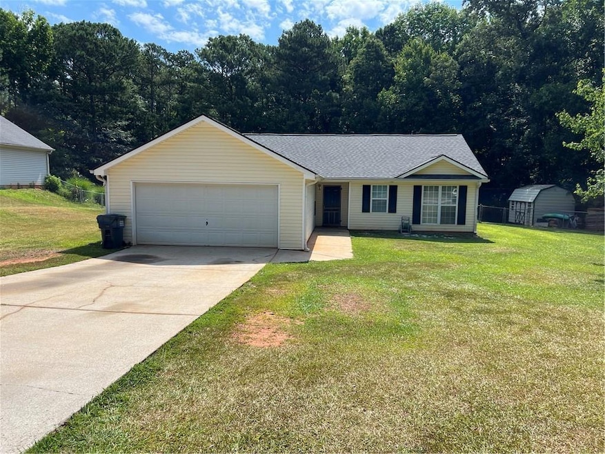 Ranch-style house with a shed, a garage, and a fro
