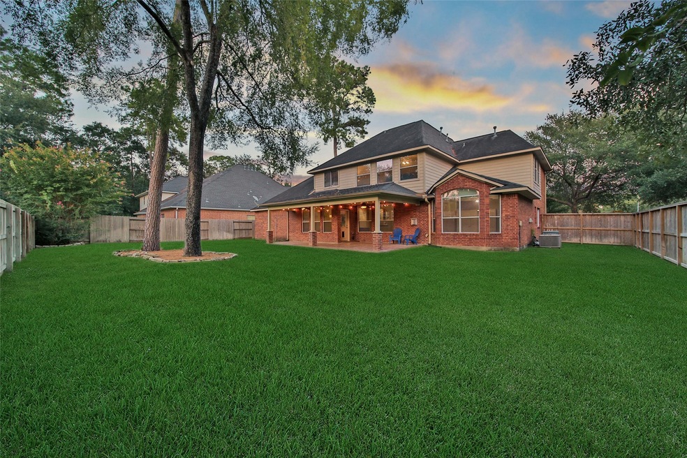 Spacious backyard featuring a covered patio area, perfect for outdoor relaxation and entertainment, all enclosed by a wooden privacy fence.