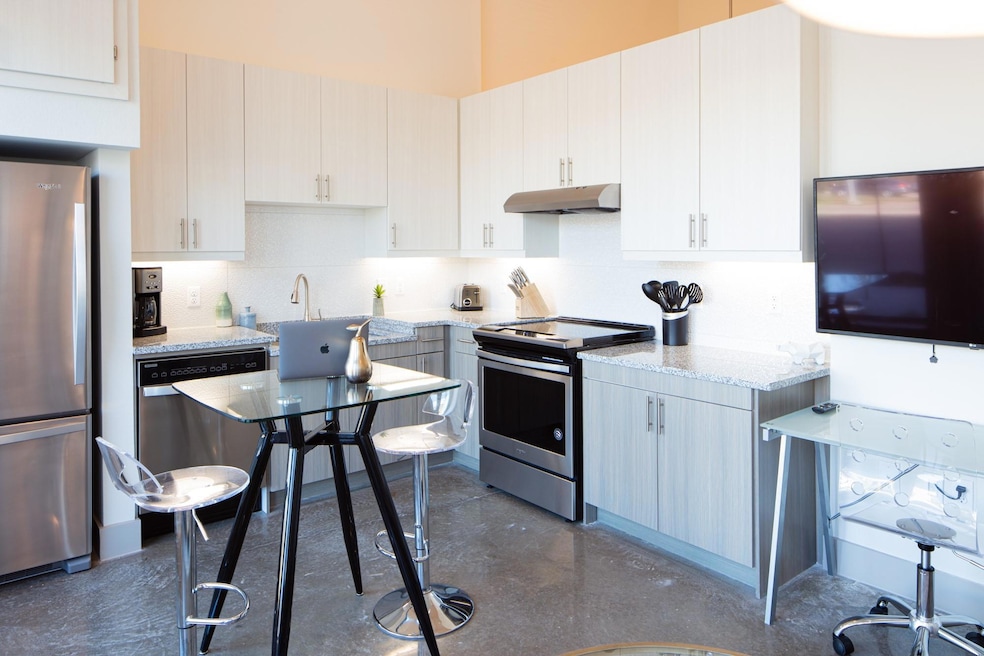 Kitchen with backsplash, white cabinetry, light st