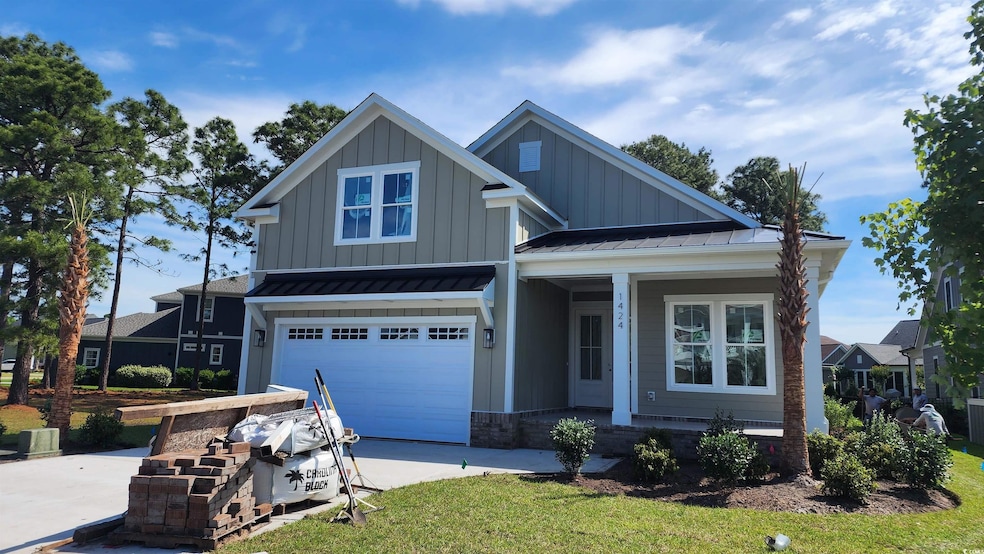 View of front of home with board and batten siding, a porch, an attached garage, driveway, and metal roof
