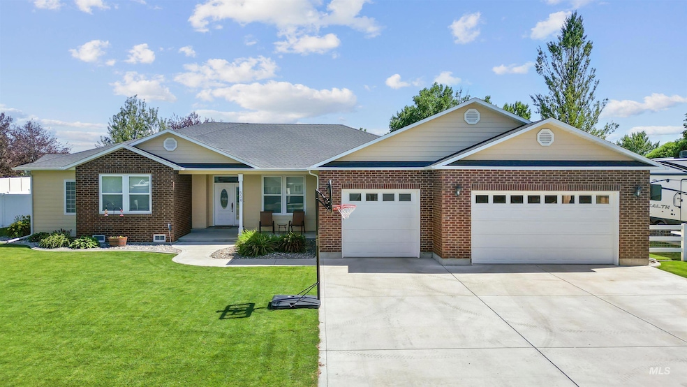 Single story home featuring an attached garage, driveway, a front lawn, and brick siding