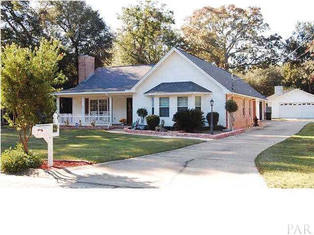Front of home with view of side entry garage at back of home, and detached garage/workshop.