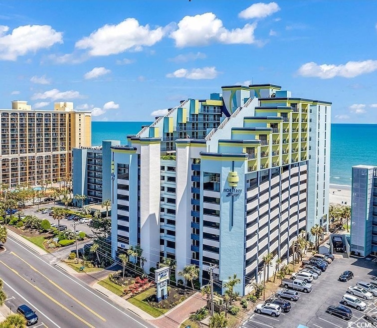 View of apartment building / complex with uncovered parking and a water view