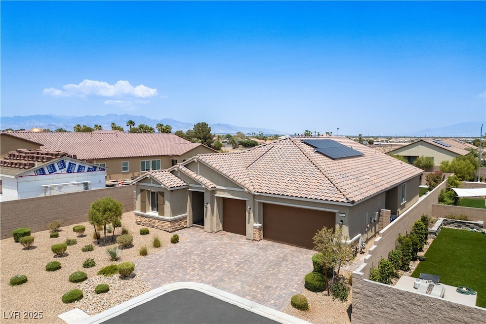 Mediterranean / spanish-style house featuring stucco siding, decorative driveway, solar panels, and stone siding