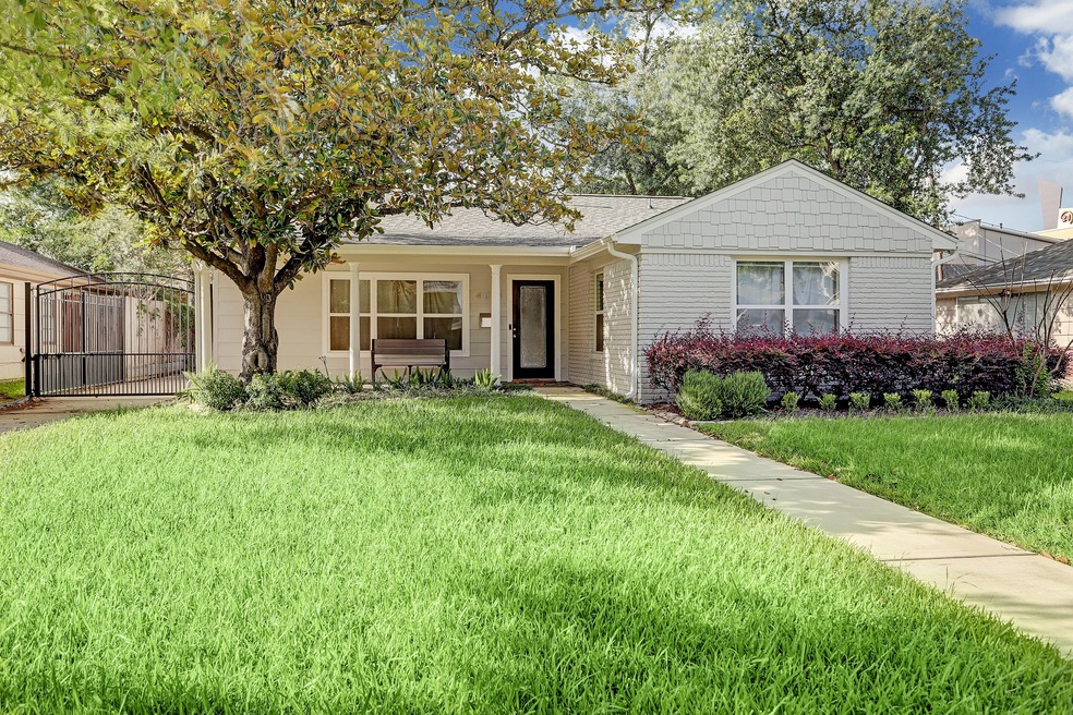 A mature tree, lush landscaping and extensive exte