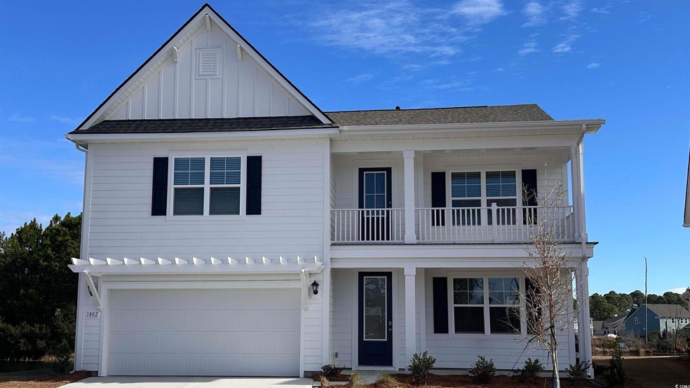 View of front of house with a balcony, board and batten siding, covered porch, an attached garage, and driveway