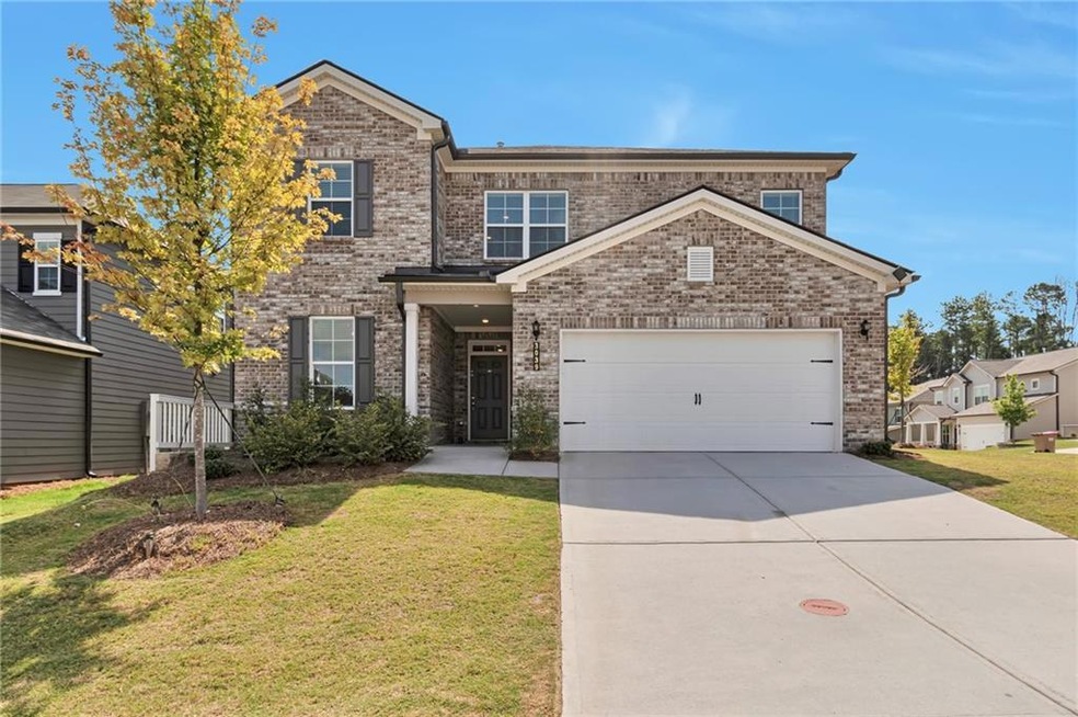 View of property featuring a garage and a front yard