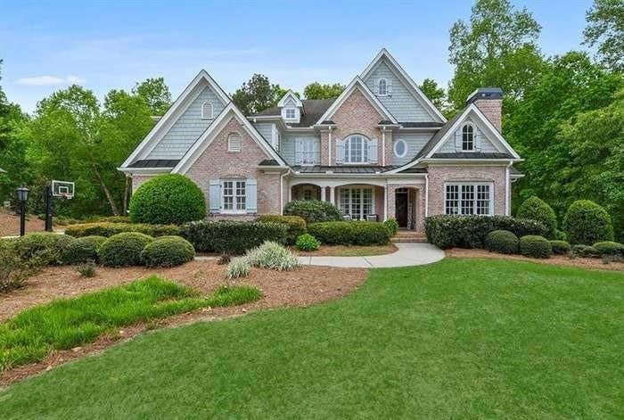 Craftsman-style house featuring a chimney, brick s