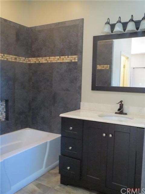 Tiled bath and modern vanity.