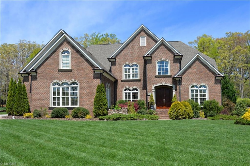 This custom home, built by Phillip Thomas, is located in the Sutton Oaks subdivision of Sedgefield and features professional landscaping, brick with stone architectural accents and a gas lantern.