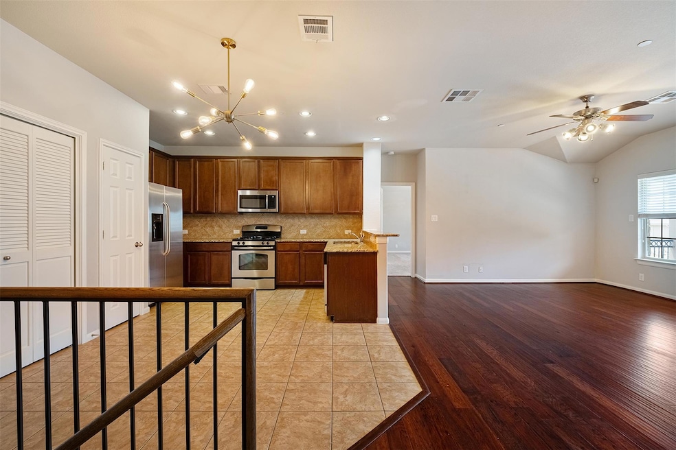 Kitchen featuring decorative backsplash, recessed lighting, a chandelier, stainless steel appliances, and brown cabinetry