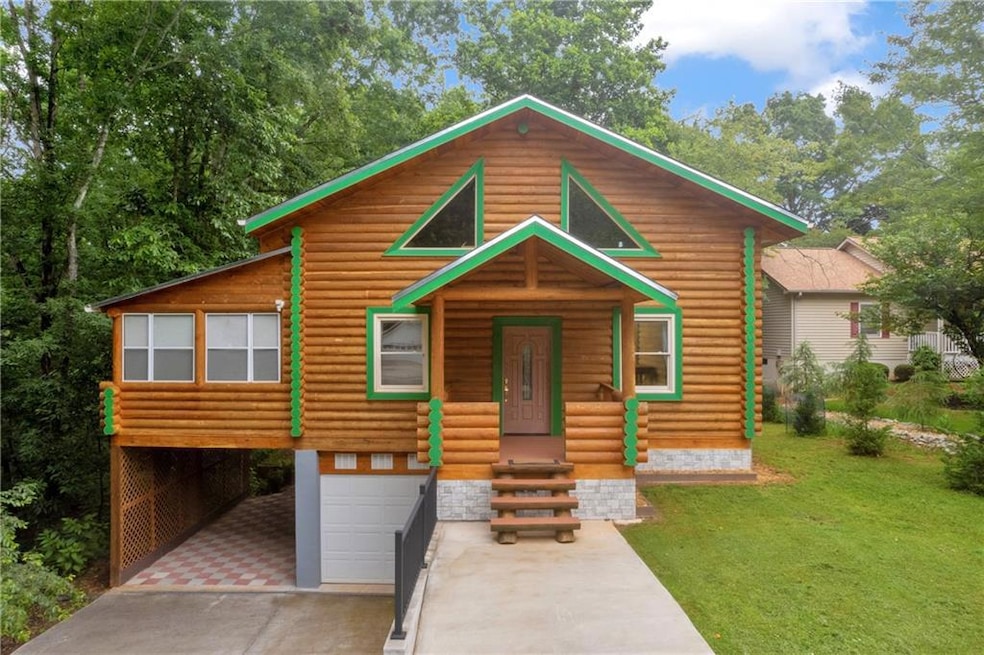 View of front of house featuring concrete driveway, an attached garage, a porch, log siding, and a front yard