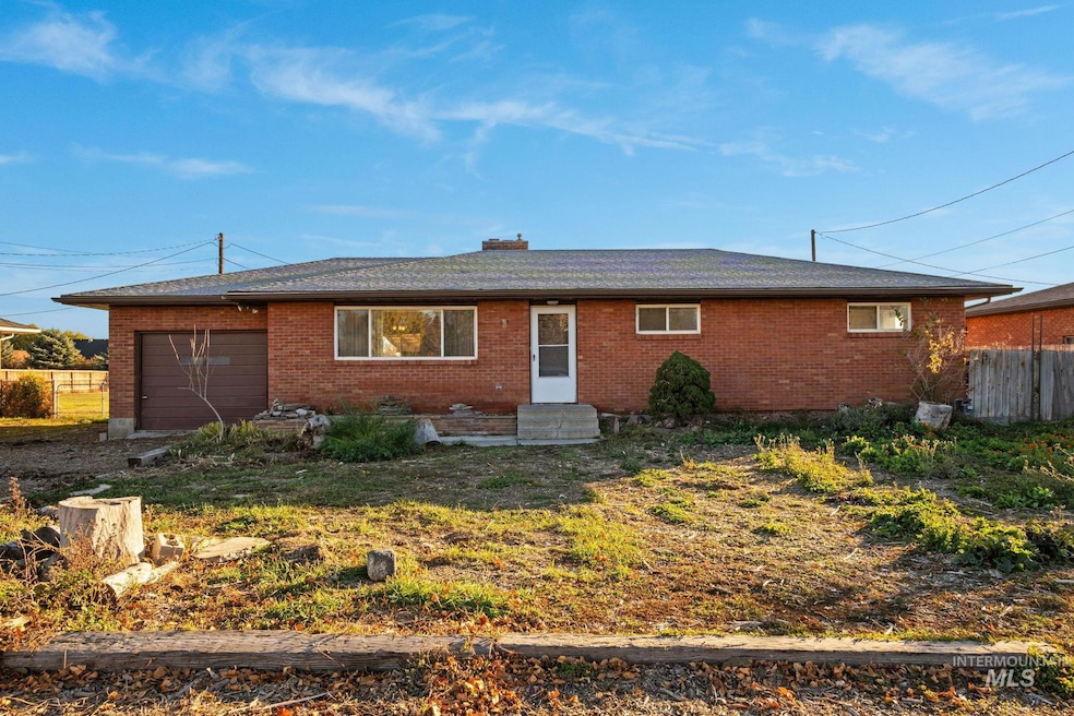Single story home with brick siding, a garage, entry steps, and a chimney