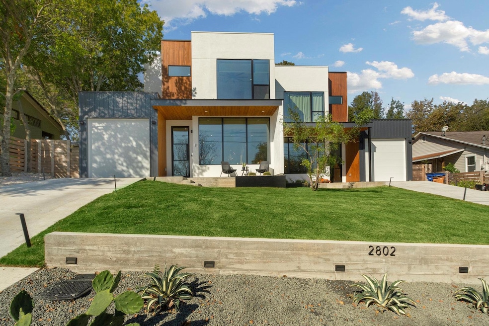 Contemporary home featuring a front lawn and driv
