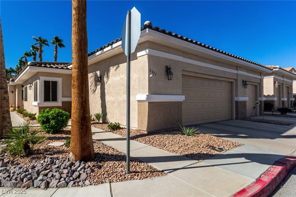 View of home's exterior with stucco siding, driveway, a tile roof, and a garage