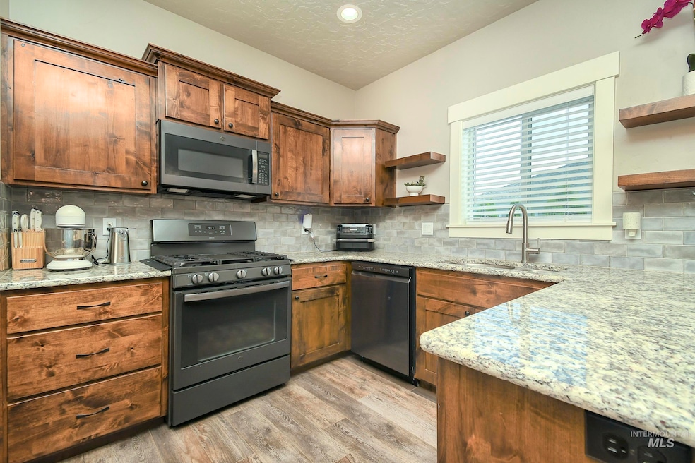 Kitchen with stainless steel microwave, open shelves, gas range, dishwashing machine, and light wood-style flooring