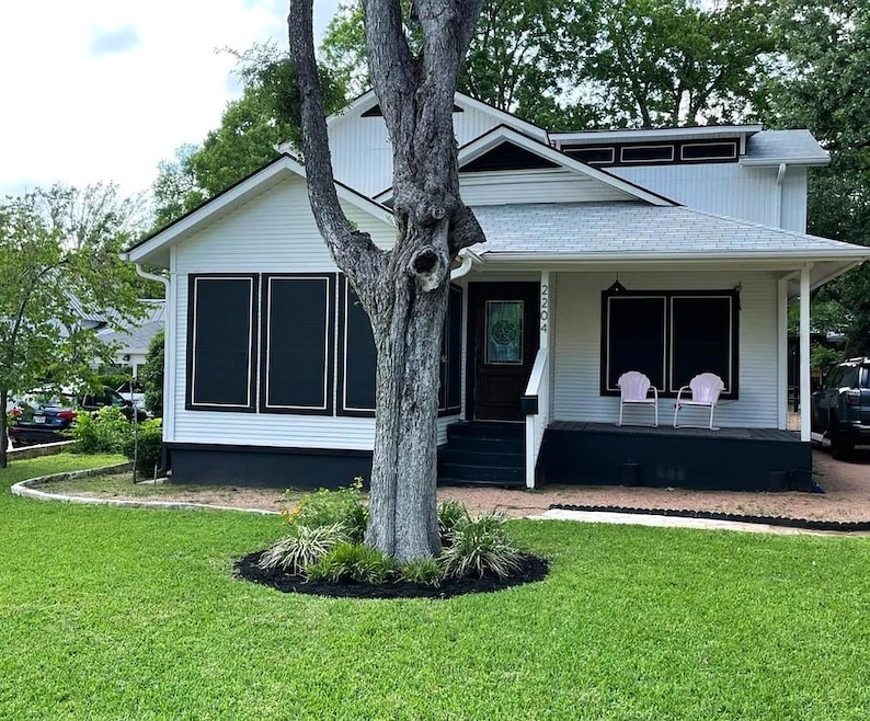 View of front of house with a front lawn and a po
