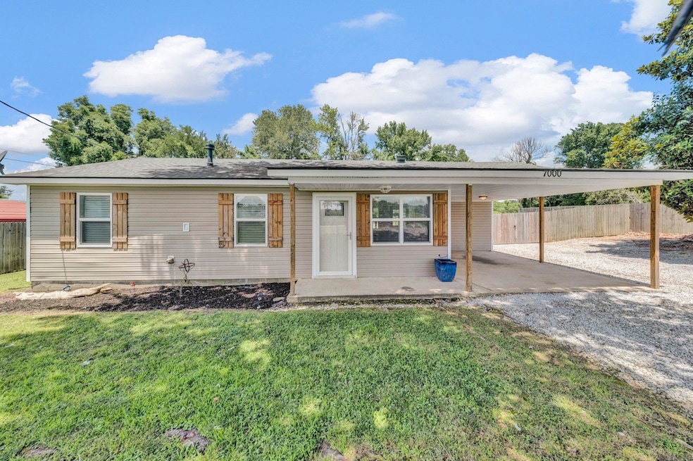 Ranch-style house featuring a carport and driveway