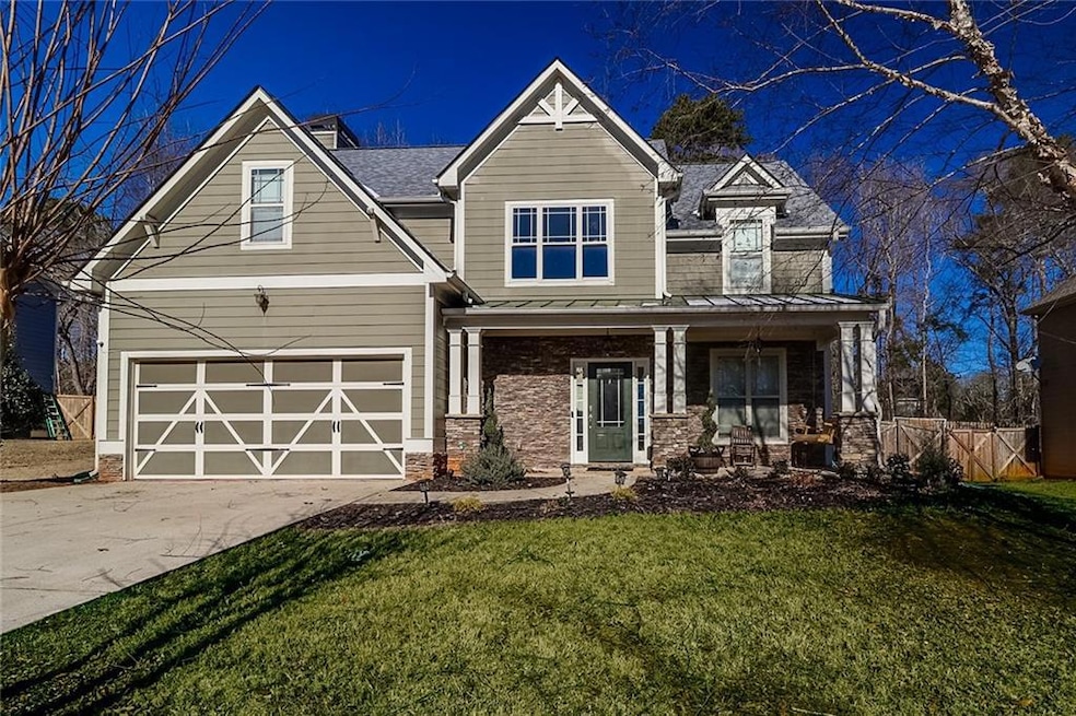 Craftsman house with a standing seam roof, concrete driveway, a porch, an attached garage, and a metal roof