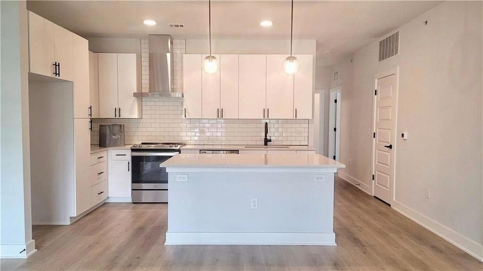 Kitchen with wall chimney exhaust hood, stainless