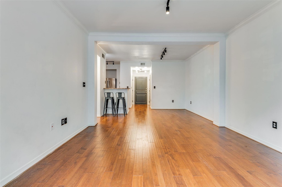 Living room with ornamental molding, light Hardwoo