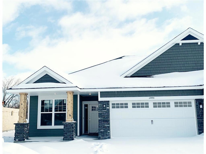 Actual Photo of home, with stone front, full front porch and deep 2 car garage.