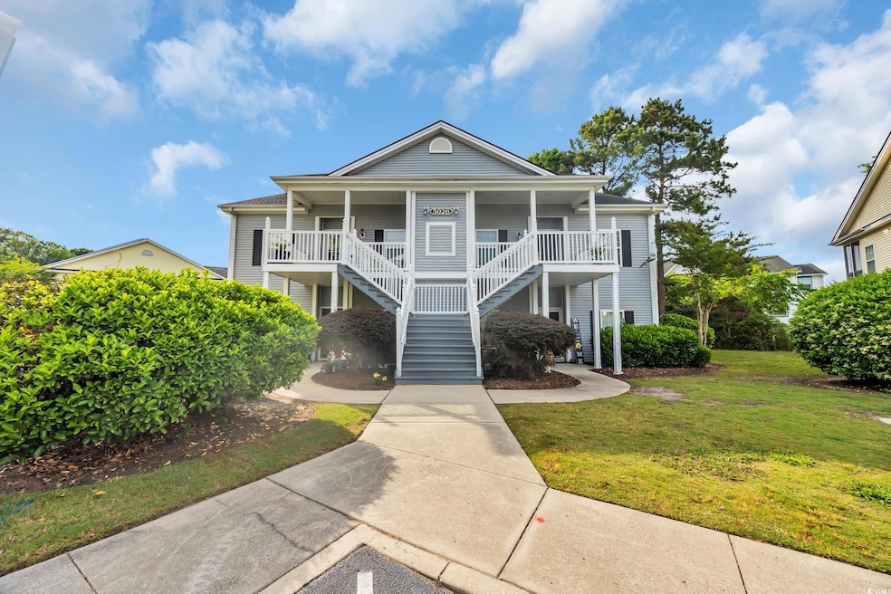 Beach home with a front yard, covered porch, and s