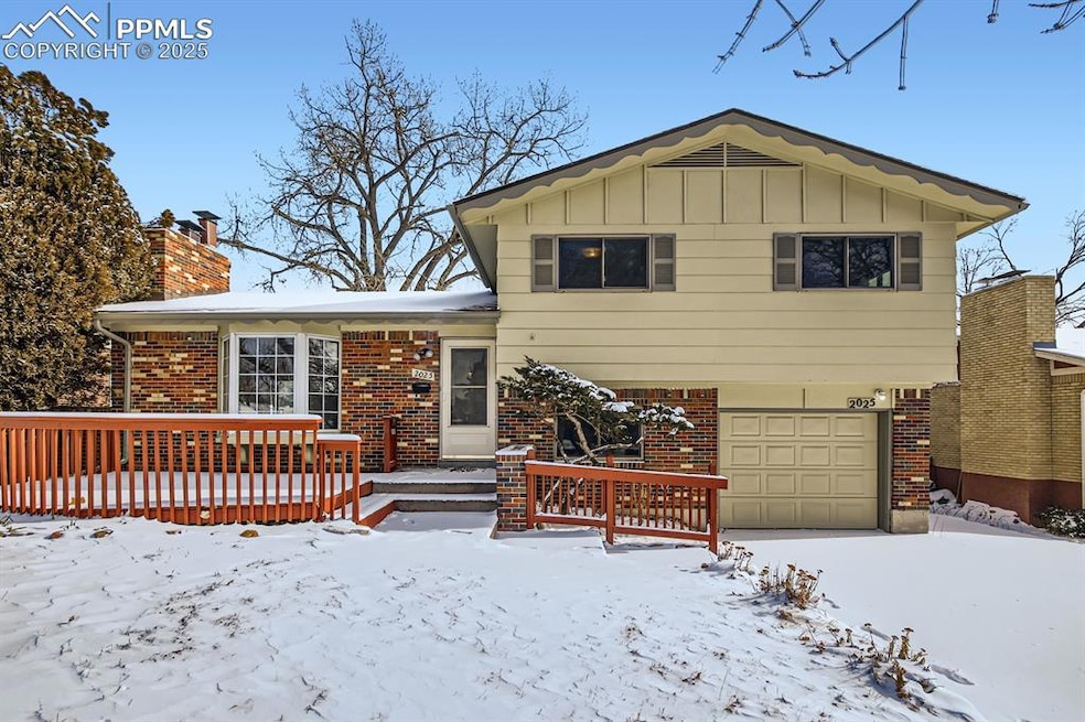 Split level home featuring a garage and a wooden d