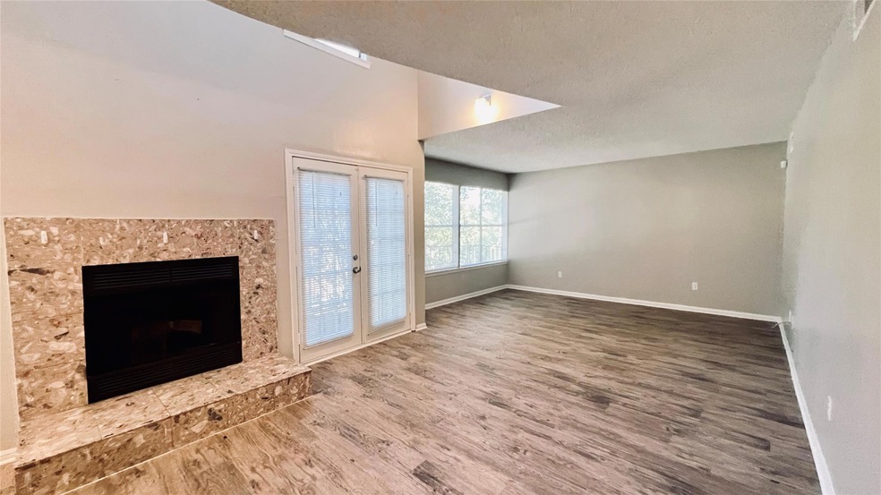 Unfurnished living room featuring baseboards, woo