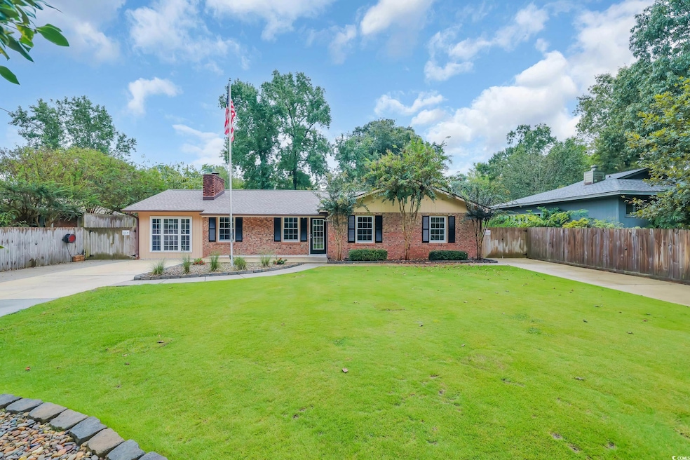 Ranch-style house with a chimney and brick siding