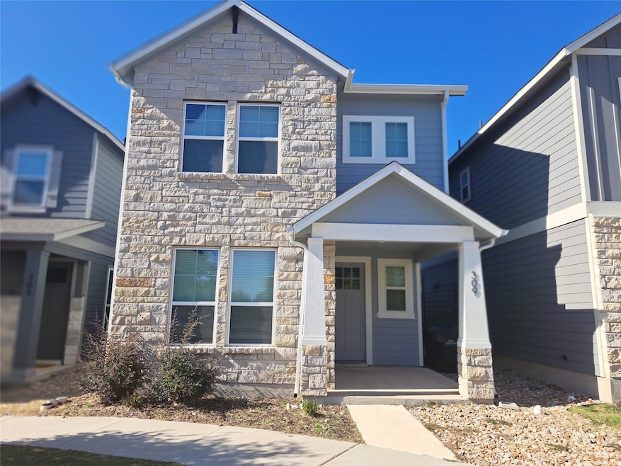 Craftsman-style home with stone siding and covere