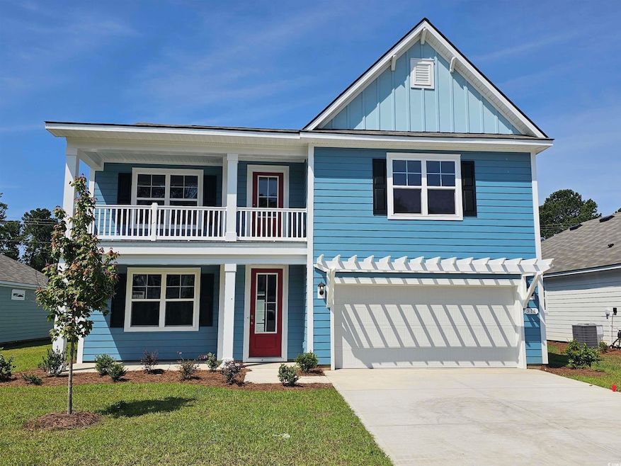 View of front facade featuring a balcony, board and batten siding, driveway, a garage, and a front lawn