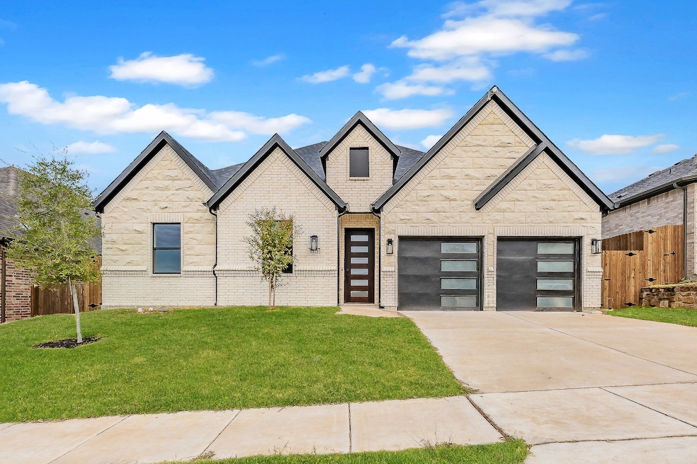 View of front facade with driveway, brick siding, roof with shingles, and a garage