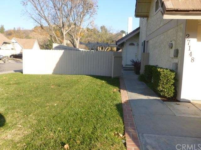 Brick edging on long sidewalk from driveway to front door.  One side patio cover on left.
