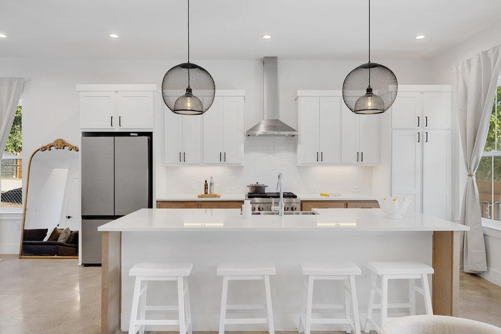 Kitchen with plenty of natural light, white cabinetry, an island with sink, and recessed lighting